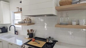 A modern kitchen with white cabinets, a black stove, and a wooden countertop. - Perfect for large groups, lots of parking, 5BRs, Game Room, Fast Wifi (Kitchener)