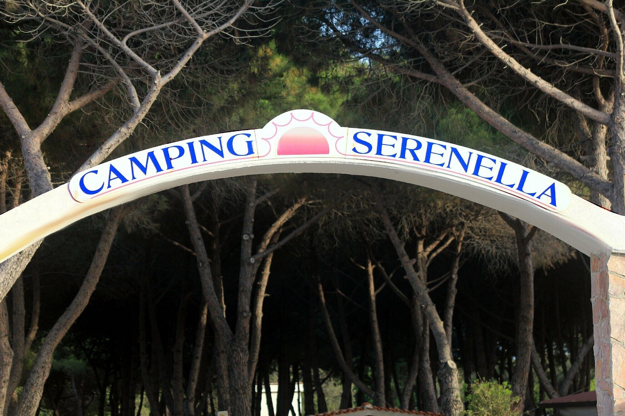 A sign with the words "CAMPING SERENELLA" indicating a camping area.