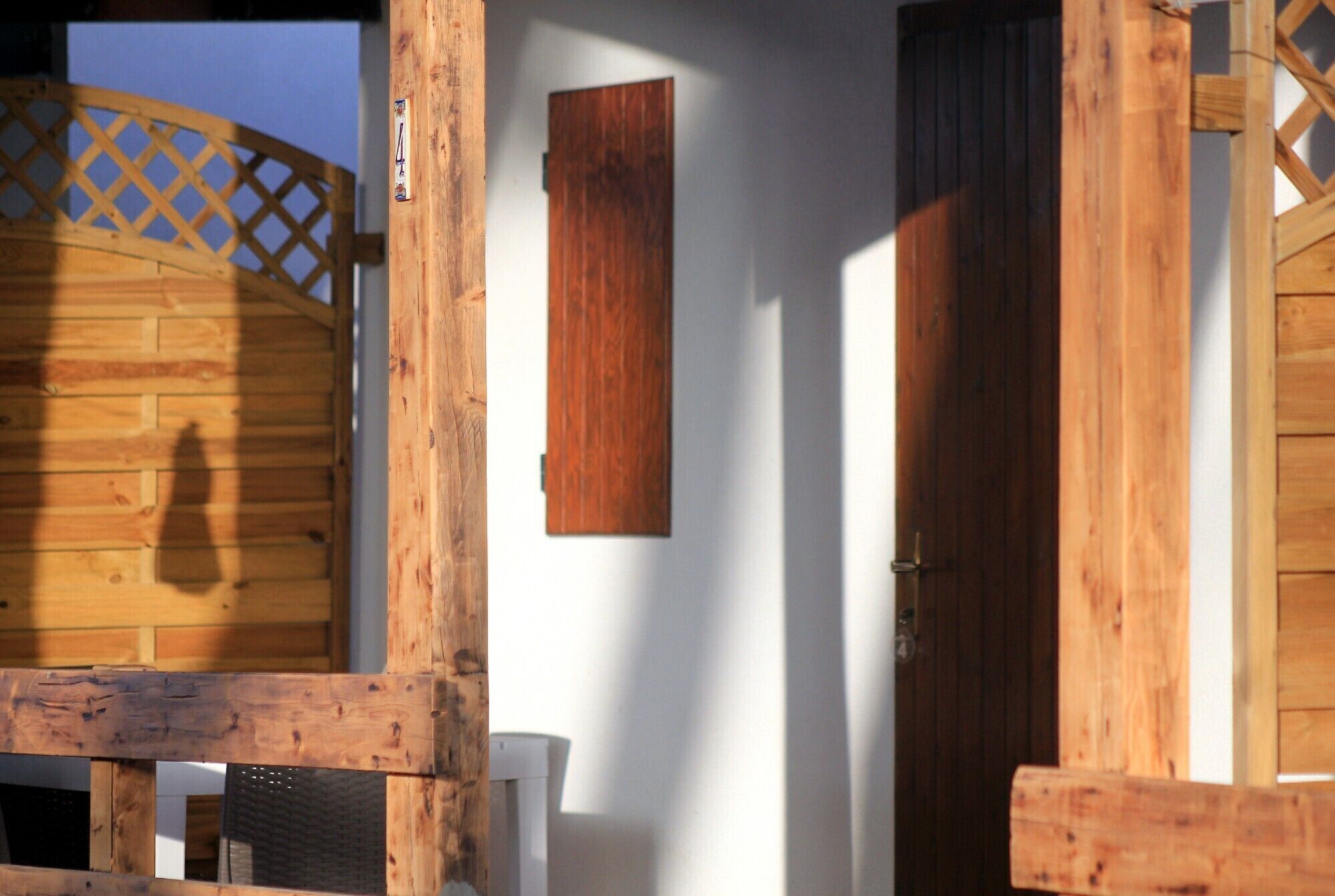 Una estructura de madera con una puerta y una ventana, parte del exterior de un edificio.