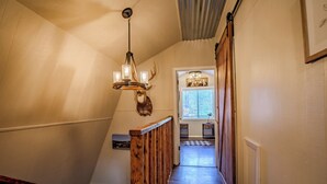 Una escalera con barandilla de madera y un candelabro.