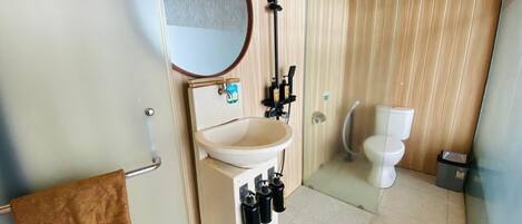 A compact bathroom with a sink, mirror, towel rack, and toilet.