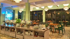 Un buffet avec plusieurs points de service, des chaises et des tables disposées dans un espace de restauration spacieux.