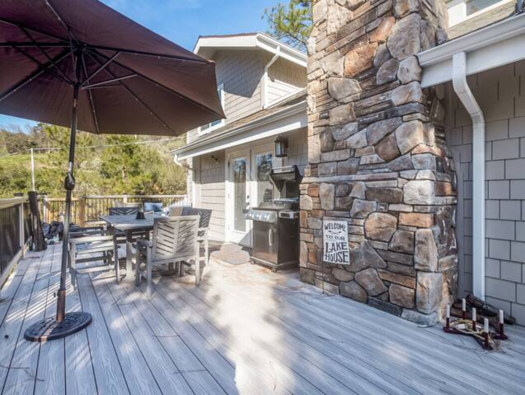 Une terrasse dotée de mobilier d’extérieur, d’un pilier en pierre et d’un barbecue.