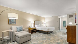 Une chambre d’hôtel avec un lit, un canapé, un bureau et une chaise.