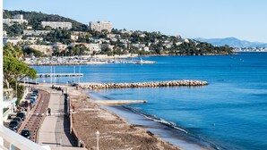A coastal cityscape with a marina, buildings, and a beach. - PANORAMIC SEA VIEW - 2-Br Apartment Mouré Rouge (Cannes)