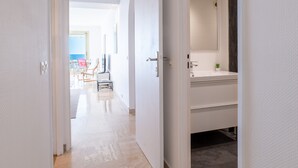 A modern bathroom with a large mirror, a sink, and a potted plant. - PANORAMIC SEA VIEW - 2-Br Apartment Mouré Rouge (Cannes)