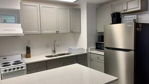 A modern kitchen with white cabinets, stainless steel appliances, and a countertop.
