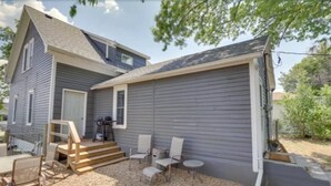 A two-story house with a covered porch, outdoor seating, and a gravel driveway. - Cozy Little Getaway, Winner, SD (Winner)