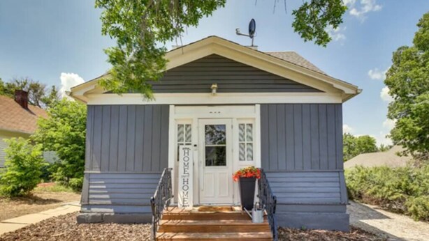 A small, single-story house with a front porch, a mailbox, and a satellite dish. - Cozy Little Getaway, Winner, SD (Winner)