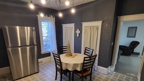 A kitchen with a stainless steel refrigerator, a dining table with chairs, and a chandelier. - Cozy Little Getaway, Winner, SD (Winner)