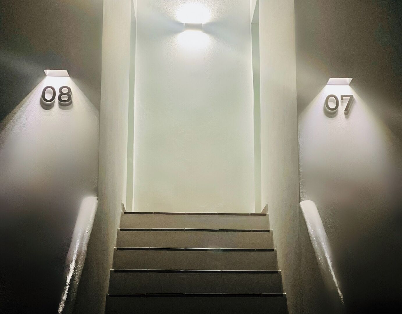 A staircase with numbers 07 and 08 on the walls, leading to a landing.