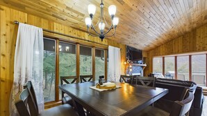 Un interno in legno con un grande tavolo da pranzo, sedie e un lampadario.