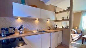 A modern kitchen with a built-in dishwasher, a sink, and a countertop with various kitchen items.