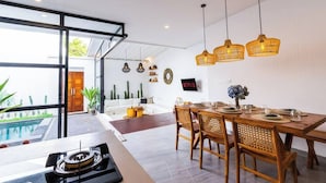 Un espace repas moderne avec vue sur la piscine, un ventilateur de plafond et un logo Netflix.