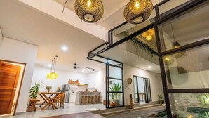 Un intérieur moderne comprenant une cuisine, un coin repas et une grande porte vitrée donnant sur un balcon.