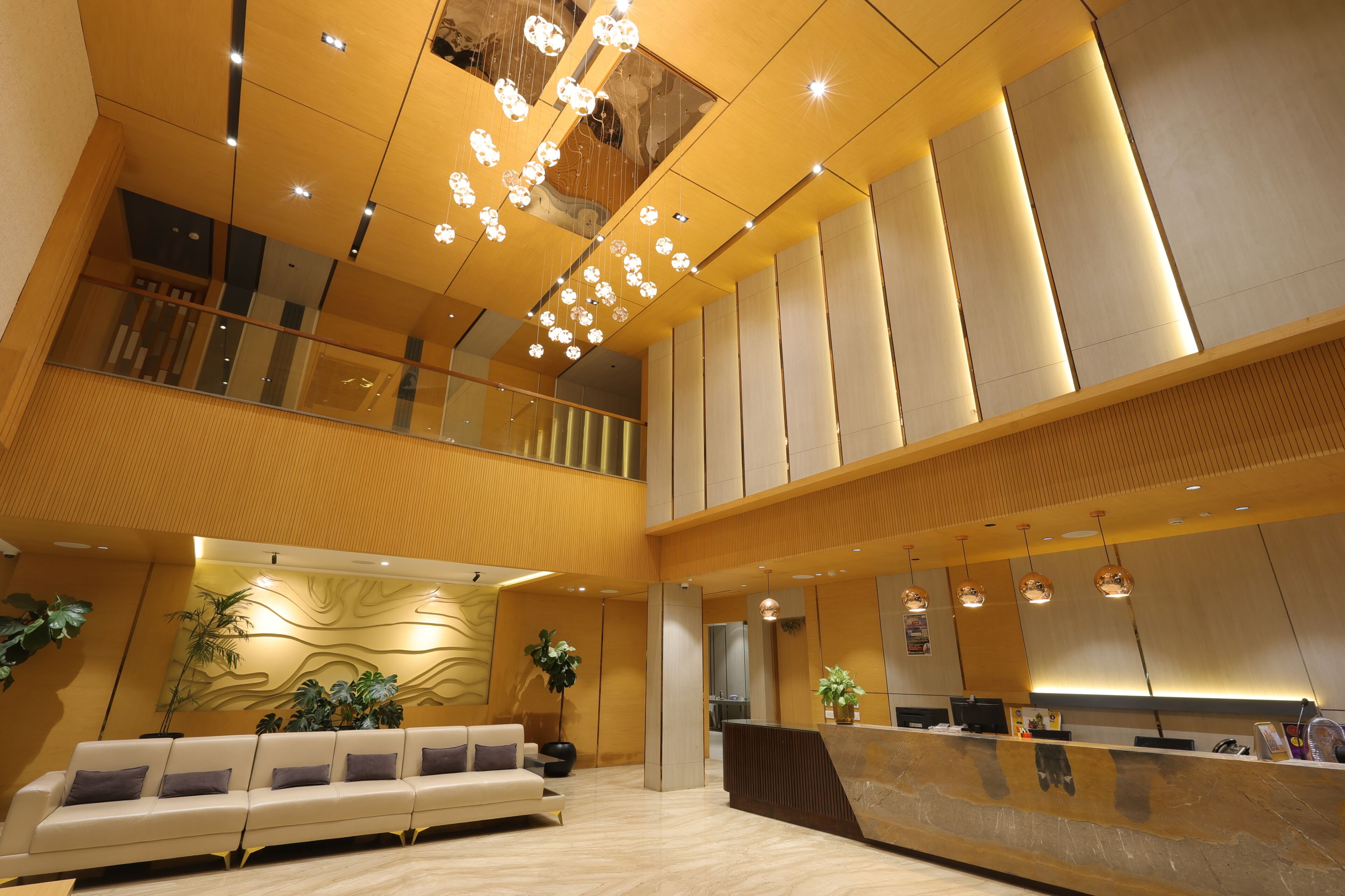 Una hall d'hotel moderna con reception, area salotto e una scala.