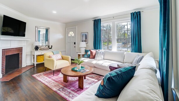 A living room with a fireplace, a sofa, a coffee table, and a TV.