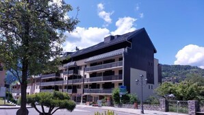 Un hôtel à plusieurs étages doté de balcons, d’un parking et offrant une vue sur un paysage montagneux.