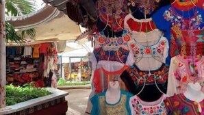 Verschillende soorten kleurrijke kinderkleding in een marktomgeving.