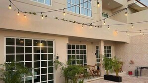 Een gebouw met grote ramen, terras en lichtjes.