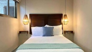 Een hotelkamer met een groot bed, twee bedlampen en een raam.