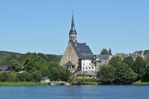 Eine Kirche mit einem hohen Turm, einer Uhr und einem Solarpaneel auf dem Dach.