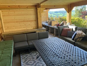 Un interior de madera con un sofá, una mesa y vistas al exterior.