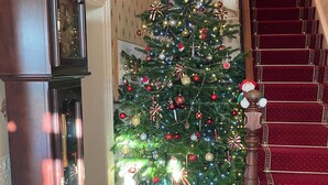 Una gran escalera decorada con un árbol de Navidad adornado con adornos y luces.