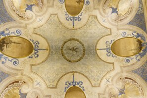 A ceiling with intricate blue and gold patterns, including floral motifs and a central circular design. - Sisuites (Bari)