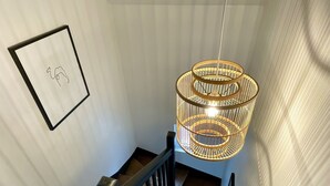 Eine Treppe mit Holzwurf und einer Pendelleuchte mit kreisförmigem Design.