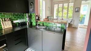 Eine moderne Küche mit schwarzem Arbeitsplatz, grüner Rückwand und einem eingebauten Herd.