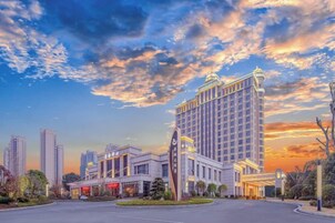 A hotel with a modern design, featuring a prominent entrance and a large building with a unique facade.