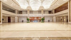 A spacious lobby with a high ceiling, large chandeliers, and a central seating area. - Ronghu Hotel (Yueyang County)