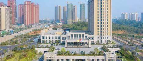 A high-rise building with a central courtyard and multiple smaller buildings around it.
