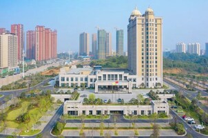 Un edificio de gran altura con un patio central y varios edificios más pequeños a su alrededor.