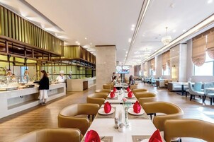 Un restaurante moderno con una barra alargada, varias mesas y una zona de bar.