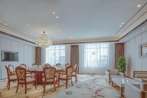 A dining room with a round table and chairs, a chandelier, and a large window with curtains. - Ronghu Hotel (Yueyang County)