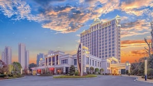 A modern hotel with a central tower, multiple wings, and a landscaped entrance area. - Ronghu Hotel (Yueyang County)