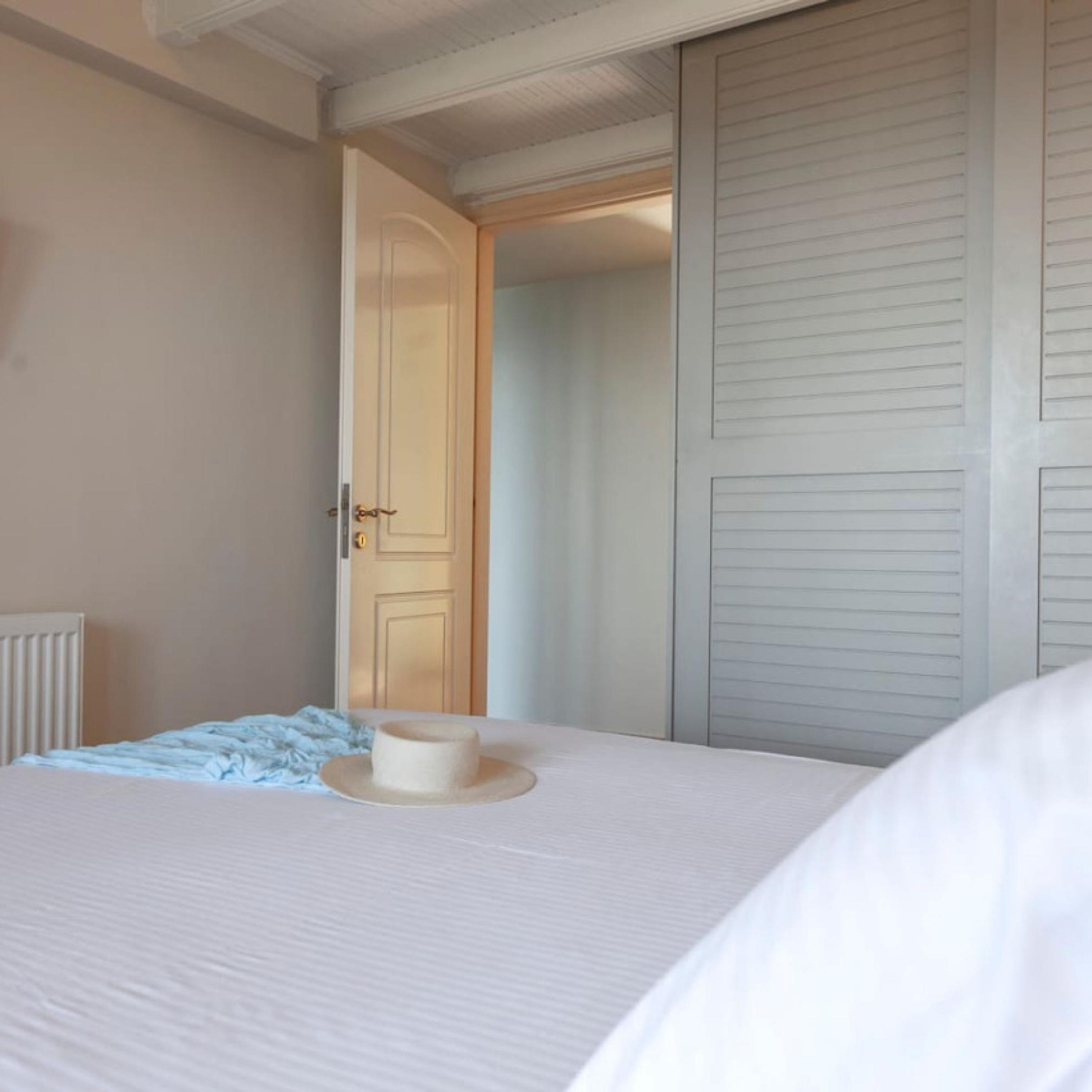 Une chambre à coucher avec un lit, une table de chevet, une porte et un placard.