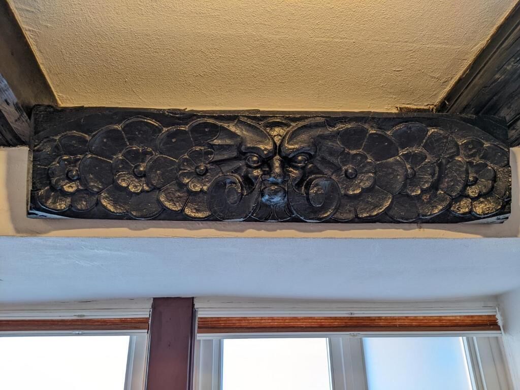 A decorative metal panel with floral and animal motifs.