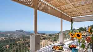 A balcony with a table set for breakfast, a view of the countryside, and a pergola structure. - New Villa with spectacular 180° Sea View,Private Pool & BBQ,5 min from the Beach (Rethymnon)