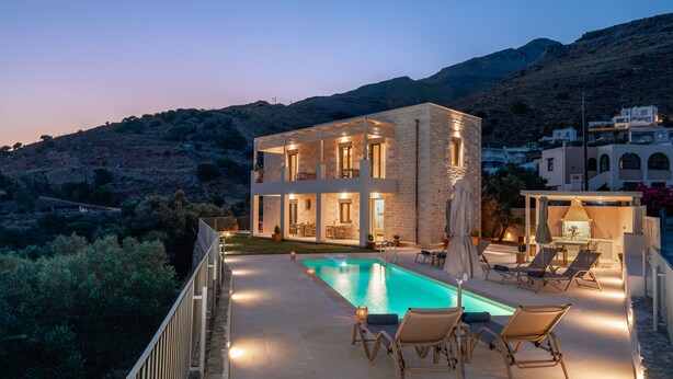A modern two-story house with a swimming pool, outdoor seating, and a view of the surrounding hills. - New Villa with spectacular 180° Sea View,Private Pool & BBQ,5 min from the Beach (Rethymnon)