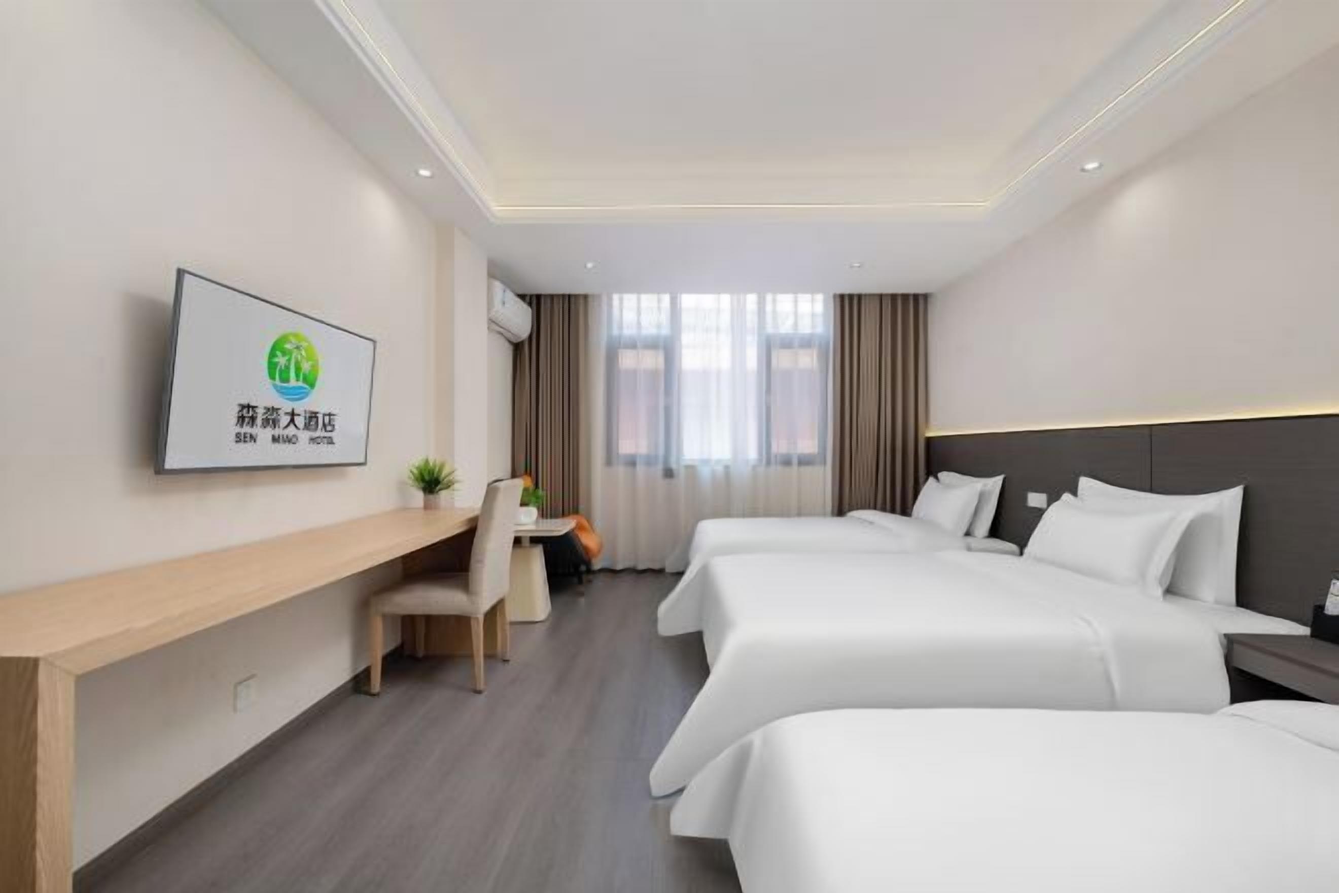 Een hotelkamer met twee bedden, een bureau en een stoel.