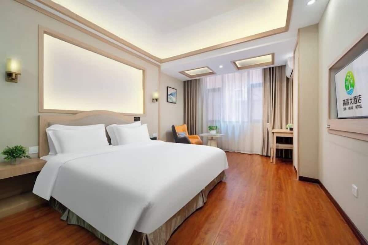 Une chambre d’hôtel avec un grand lit, un bureau et une chaise.