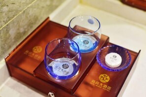 Trois récipients en verre, chacun portant une étiquette, sont disposés sur un plateau en bois.