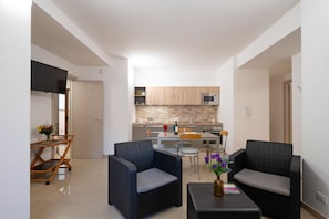 Un apartamento moderno con cocina, comedor y dos sofás.