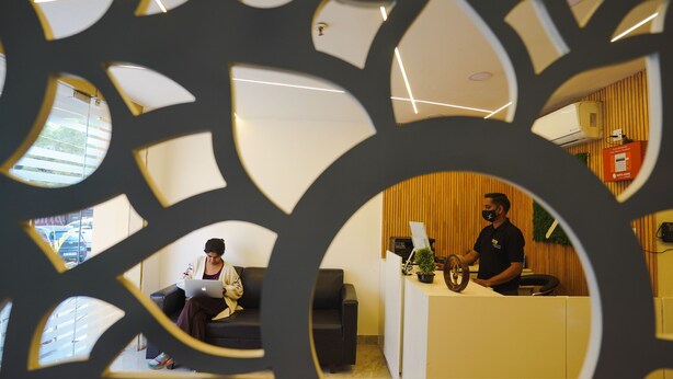 A reception area with a receptionist, a waiting area with a sofa, and a reception desk. - Hotel Northwind Mohali (Kharar)