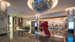 A lobby with marble flooring, a central seating area, and a large decorative globe. - Jinlongtan jiudian (Zhaodong)