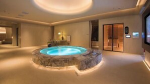 A spa area with a hot tub, a reception desk, and a wooden door. - Jinlongtan jiudian (Zhaodong)