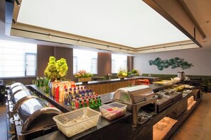 A buffet area with various food items and condiments.